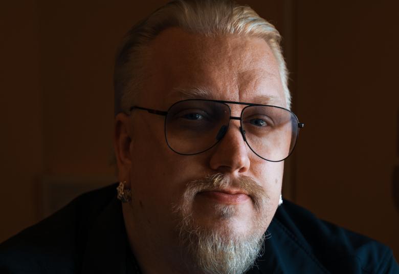 Kuvassa on Arttu Wiskari kasvokuvassa ja kasvoista näkyy hyvin noin puolet. Kuva on tumma.