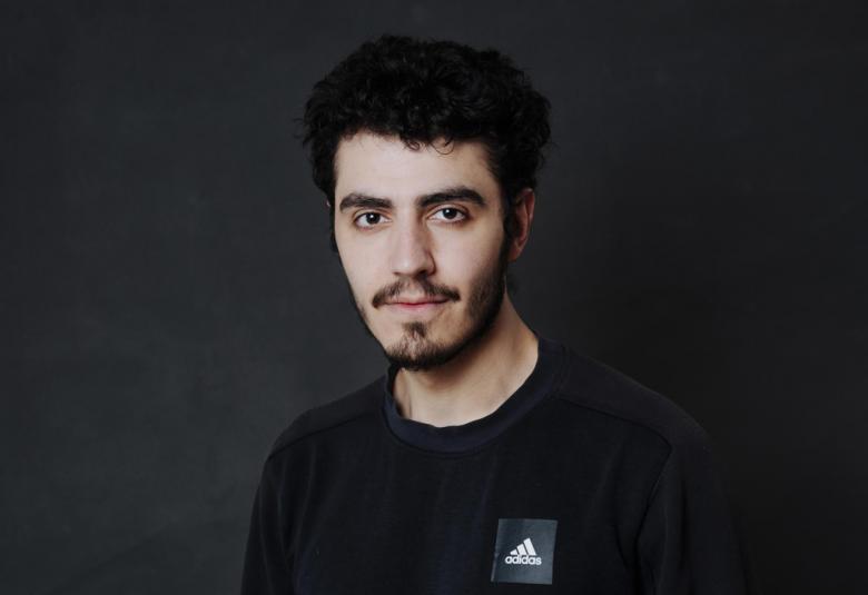Kuvassa on Youssef Asad Alkhatib puolivartalokuvassa. Hänellä on musta t-paita. Tausta on tumma.