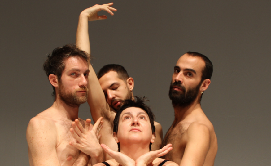 Kuvassa on viisi miestanssijaa tiiviinä ryhmänä ja kahdella heistä on yläruumis paljaana. Takana oleva ojentaa oikeaa kättään.