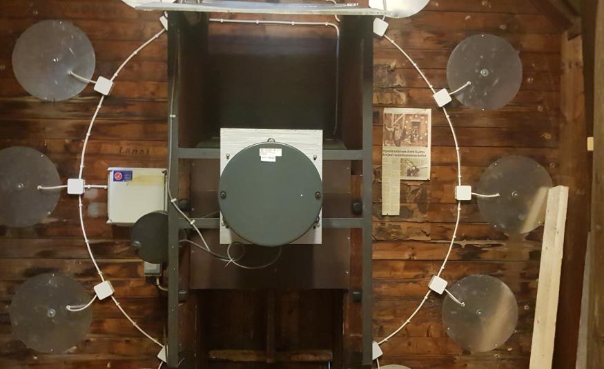 Kuvassa on iso ikkuna, josta näkyy asemahalliin ja siellä kävelee ihmisiä. Edessä näkyy pöytää ja molemmin puolin on vaalean ruskeat pylväät.