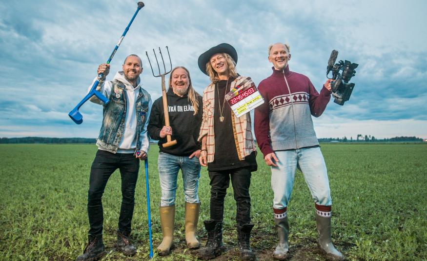 Kuvassa ovat Duudsonien neljä miestä ja heillä on erilaisia työvälineitä kädessään kuten talikko ja golfmaila. Heillä on eri värisiä farkkuja ja puseroita päällään. Taustalla on sini-valkoista taivasta ja alla vihreää heinäpeltoa.