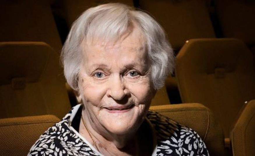 Kuvassa on Eila Roineen kasvokuva ja hänellä on vaalentuneet hiukset. Kuvassa näkyy musta-valkoisen puseron kaula-aukkoa. Taustalla on ruskeita teatterikatsoman tuoleja.