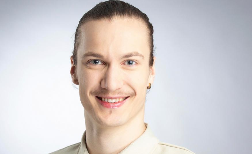  Kuvassa on Samuli Emery kasvokuvassa. Hänellä on kellertävä paita päällään. Tausta on vaalea.