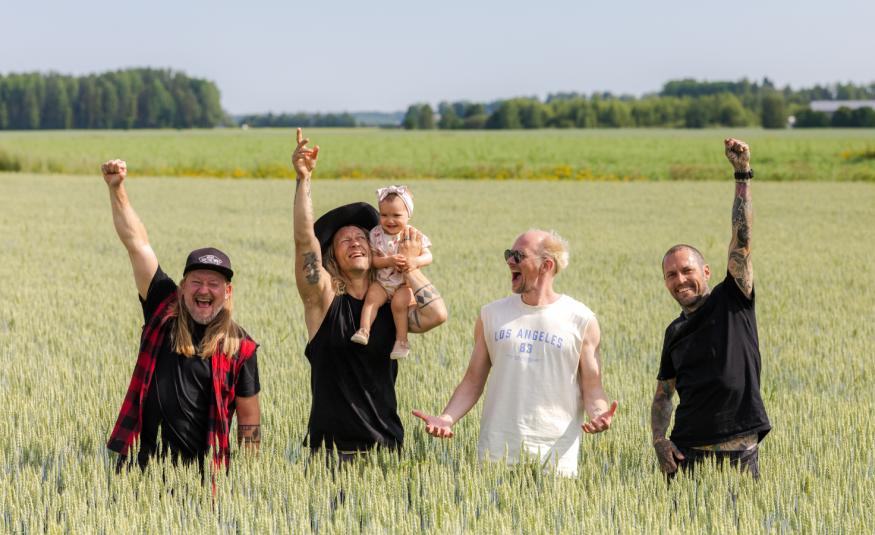 Kuvassa ovat Duudsonien neljä veljestä seisomassa keltaisessa viljapellossa. ja he vilkuttavat. Vasemmalta toisena olevalla on vauva olkapäällään.