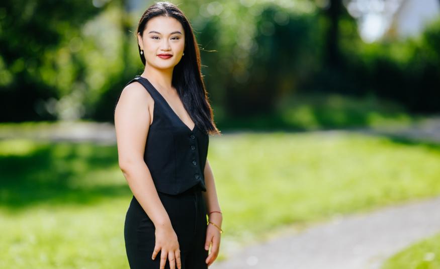 Kuvassa on Jingjing Xu seisomassa mustassa hihattomassa mekossa. Taustalla on vihreätä puistoa.