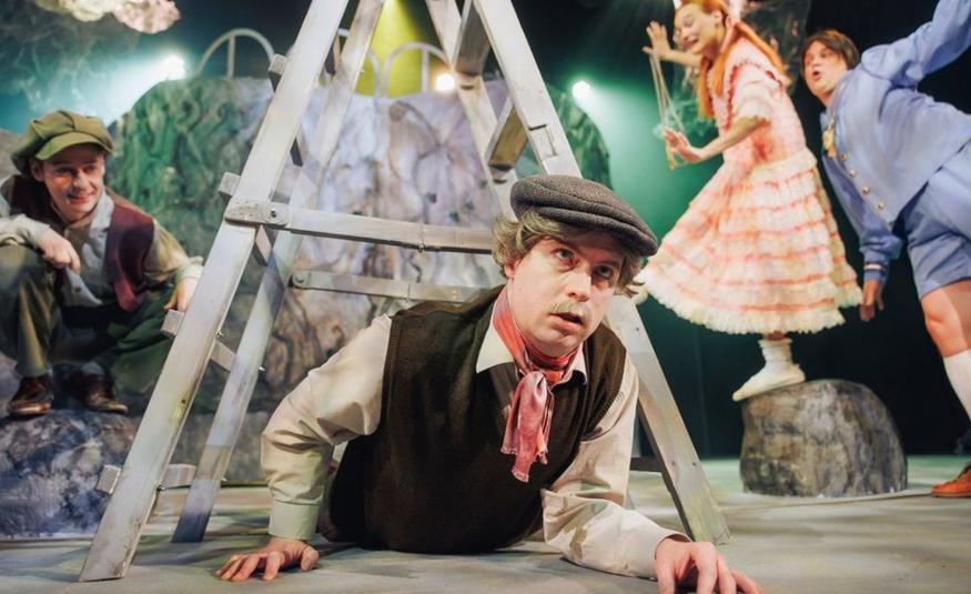 Kuvassa on nuori mies lippalakissa ja tummassa liivissä sekä vaaleassa paidassa. Hän ryömii harmaiden kolmiotikkaiden ali. Oikealla istuu poika kyykyssä kiven päällä ja hänellä on samanlaiset vaatteet. Oikealla näkyy tytön vaalean oranssi rimpsuhame. Hänen oikealla puolellaan on pikku poika vaalean sinisessä housupuvussa.