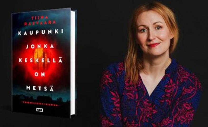 Kuvassa on vasemmalla kirjan kansi ja siinä monella rivillä kirjan nimi valkoisella Kaupunki jonka keskellä on kylä. Tausta on tumma ja siinä on punainen pyörylä keskellä. Oikealla on Tiina Raevaara ja hänellä on mustaä pusero päällään. Kuvan tausta on musta.