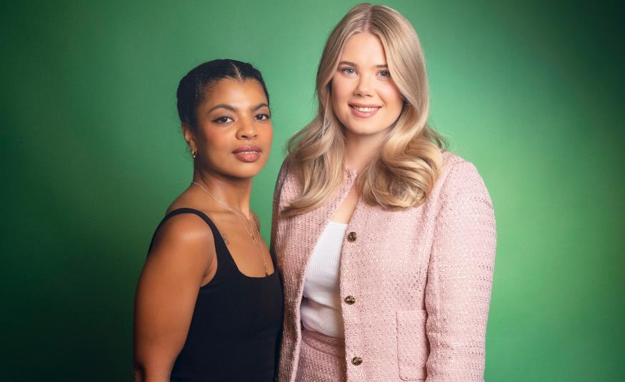 Kuvassa on vasemmalla Yasmine Yamajako mustassa hihattomassa t-paidassa. Hänen vieressään oikealla seisää vaalean punaisessa jakussa Nomi Enckell. Tausta on vihreä.