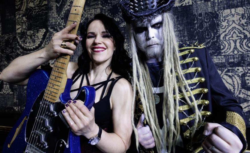 Kuvassa on vasemmalla Erja Lyytinen hihattomassa,  mustassa t-paidassa ja edessään käsissään pystyssä olevaa sini-mustaa kitaraa, jossa on ruskea kaula. Oikealla on King Satan, jolla on pitkät vaaleat hiukset ja päässään nastoilla varusettu musta stetson. Hänellä on päällään kultapunostakki. Taustalla on tumman kirjavaa kangasta. 