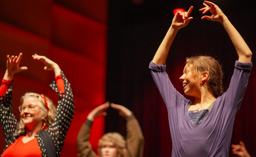 Kuvassa on puolivartalokuvassa kolme flamenco-tanssijaa ja heillä on kädet ylhäällä. Taustalla on punertavaa seinää. 