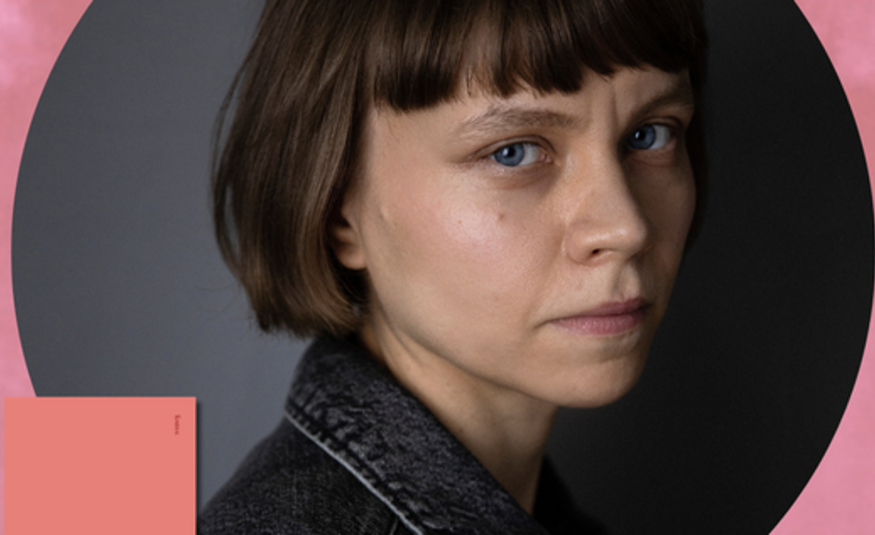 Kuvassa on Mariia Niskavaara kasvokuvassa ja hänellä on ruskea pokkatukka. Taustalla on harmaata pylristettymä ja vaalean punaista.