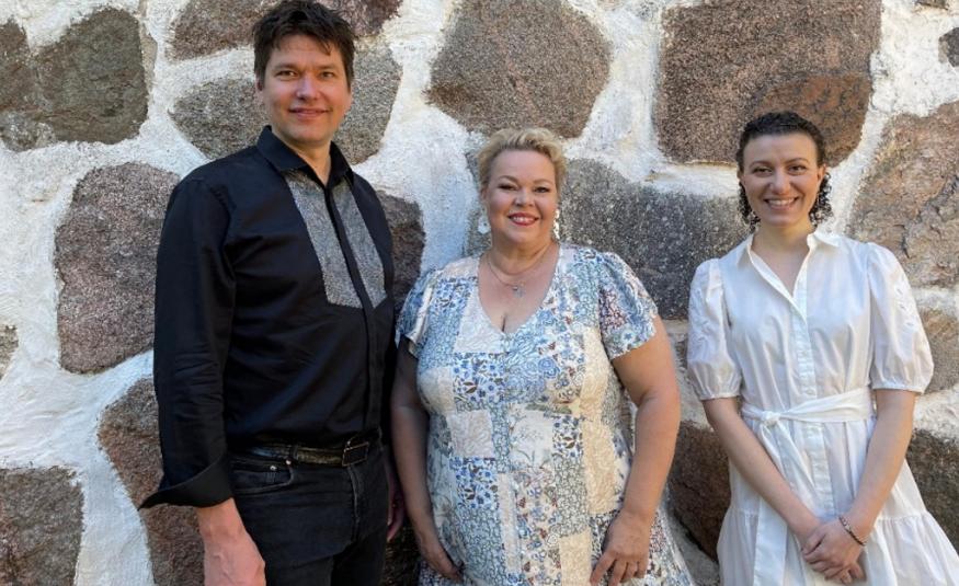 Kuvassa on vasemmalta Jussi Makkonen mustassa puserossa ja mustissa farkuissa. Vieressä on Johanna Rusanen-Kartano vaalean sini-valkoisessa mekossa ja oikealla Nazig Azezian valkoisessa mekossa.