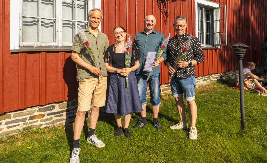 Kuvassa on yhtye Freijan neljä esiintyjää ja vasemmalla on mies, jolla on vihertävä paita ja kellertävät shortsit. Hänen oikealla puolellaan on nainen sinisessä mekossa ja mies sinisessä paidassa ja farkkushortseissa. Vasemmalla on mies valkopilkulisessa paidassa ja sinisissä farkkushortseissa. Taustalla on punainen puurakennusta ja ikkuna valkoislla ikkunanpielillä.