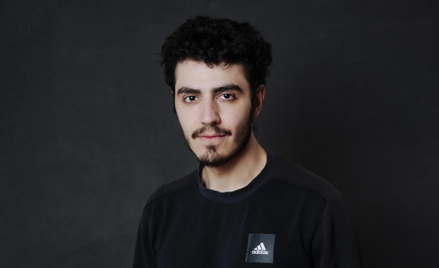Kuvassa on Youssef Asad Alkhatib puolivartalokuvassa. Hänellä on musta t-paita. Tausta on tumma.
