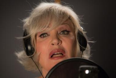 Kuvassa on Hannele Laurin kasvot kuulokkeet päässä laulamassa.