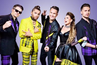 Kuvassa on Portion Boys -yhtyeen viisi jäsentä seisomassa. Vasemmalta on kolme miestä, joista keskimmäisellä keltaiset vaatteet ja muilla mustat. Toisena oikealta on nainen ja hänellä on musta mekko, jossa on keltaruudullinen helma. Oikealla on mies, jolla on mustat vaatteet.