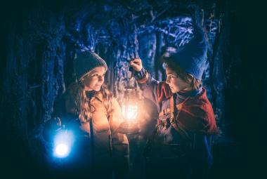 Kuvassa on yöllä lyhdyn valossa vasemmalla Soma Zimmatore sinisessä pipossa ja Marco Stylianou pitää lyhtyä sekä on sininen pipo päässään.