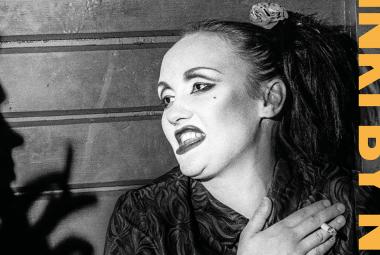 Kuvassa on nainen puolivartalokuvassa pää ja katse käännettynä vasemmalle oikeassa kädessään tupakka. Vasemmassa reunassa on miehen profiili ja kädessä tupakka. Oikeassa reunassa on pystysuorassa NKI BY N. Kuva on musta-valkoinen ja osa kirjan kantta.