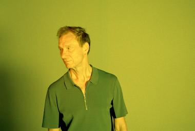 Kuvassa on Ismo Alanko puolivartalokuvassa ja hänellä on vihreä lyhythihainen pusero päällään.  Tausta ja kuvan sävy on vihreä.