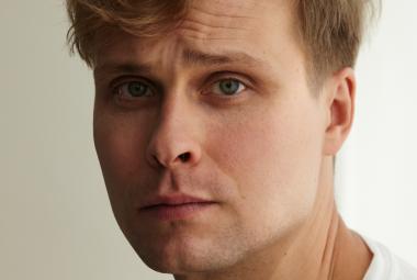 Kuvassa on Jussi Moila kasvokuvassa.  Hänellä on tuuheat ruskeat hiukset.