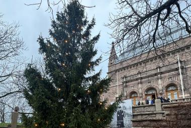 Kuvassa Turun taidemuseon päärakennus, joka on ruskea kivirakennus, jossa on kaksi pientä tornia. Vasemmalla keskellä on suuri kuusi.