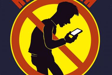 Kuvassa on mustalla pohjalla ympyrn mallinen punareunainen, keltainen kieltomerkki ja sen keskellä on miehen hahmo, joka tuijottaa kännykkää.