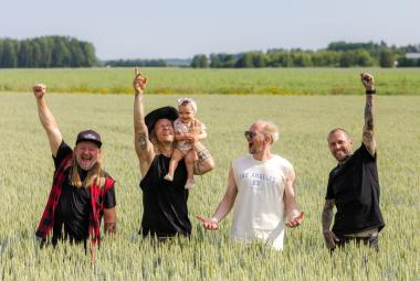 Kuvassa ovat Duudsonien neljä veljestä seisomassa keltaisessa viljapellossa. ja he vilkuttavat. Vasemmalta toisena olevalla on vauva olkapäällään.