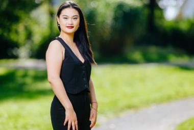 Kuvassa on Jingjing Xu seisomassa mustassa hihattomassa mekossa. Taustalla on vihreätä puistoa.