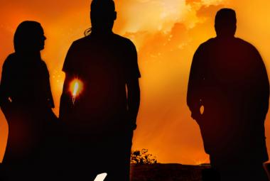 Kuvassa on kolme mustaa hahmoa katsomassa kokonaan oranssia taivasta kummun päällä.