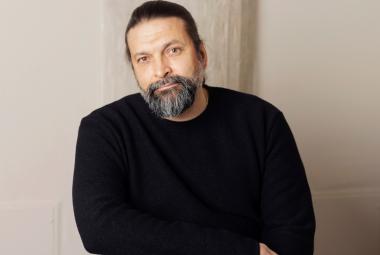 Kuvassa on Riku Saatsi puolivartalokuvassa ja hänellä on musta paita päällään. Tausta on harmahtava.