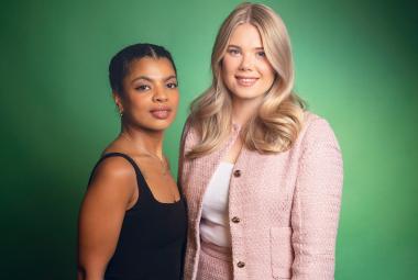 Kuvassa on vasemmalla Yasmine Yamajako mustassa hihattomassa t-paidassa. Hänen vieressään oikealla seisää vaalean punaisessa jakussa Nomi Enckell. Tausta on vihreä.