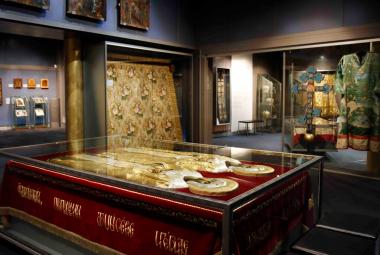 Kuvassa on museon kulmaa, jossa on tumman puun keskellä sekä ikoneja että muita teoksia. Keskellä on tummaa puuta oleva pöytä ja sen päällä kaksi kultaista hahmoa kantena.