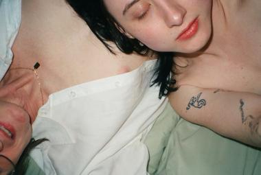 Kuvassa on kaksi naista makaamassa ristikkäin sängyssä ylhäältä päin kuvattuna. Kuvassa näkyy heidän paljasta ylävartaloaan. Oikealla näkyy tummahiuksista naista silmät suljettuina.