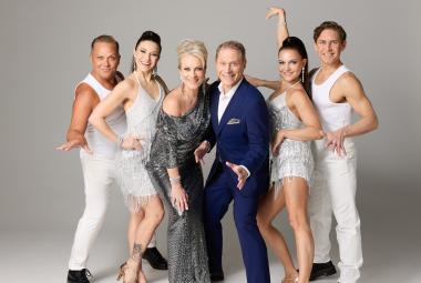 Kuvassa on kuusi esiintyjää ja vasemmalla on mies ja nainen valkoisissa asuissa, keskellä Laura Voutilainen etukumarassa vihreässä pitkässä mekossa ja hänen oikealla puolella Jarkko Tamminen mustassa puvassa.  Hänen oikealla puolellaan kaksi tanssijaa, nainen ja mies valkoisissa asuissa.