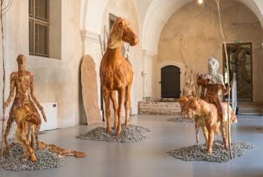 Kuvanveistäjä Edith Karlsonin näyttelyssä kävijä kohtaa nelimetrisiä jättiläisiä, salin ylle kaareutuvan luurangon ja kohti vääjäämätöntä kohtaloaan ratsastavan armeijan. Linnut ja muut eläimet tuijottavat hiljaisina vastaan. Kaivon äärellä lepäilevät merenneidot ovat nousseet vedestä todistamaan, mitä ihminen on merelle ja maalle tehnyt.  Karlsonille tarunomaiset hahmot ovat keino käsitellä kysymyksiä, joita on järkeilemälllä vaikeaa tai mahdotonta ymmärtää. Ihmisiä ja eläimiä yhdistävät vietit, sinnikäs e