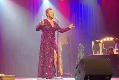 Kuvassa on Mika Tepsä pitkässä punaisessa glittermekossa. Hän laulaa mikin ääressä kädet ojennettuina ja sampanjalasi oikeassa kädessään. Taustalla on punaisella ja sinisellä valaistua seinää.