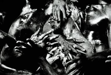 Kuvassa on sekavasti käsiä ja jalkoja sekä ruumiin osia sekavasti kasassa. Kuva on musta-valkoinen.