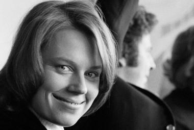 Kuvassa on Arja Saijonmaa nuorena kasvokuvass. Taustalla näkyy Mikis Theodorakis selin ja osaa kasvoista. Kuva on musta-valkoinen.