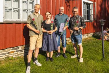 Kuvassa on yhtye Freijan neljä esiintyjää ja vasemmalla on mies, jolla on vihertävä paita ja kellertävät shortsit. Hänen oikealla puolellaan on nainen sinisessä mekossa ja mies sinisessä paidassa ja farkkushortseissa. Vasemmalla on mies valkopilkulisessa paidassa ja sinisissä farkkushortseissa. Taustalla on punainen puurakennusta ja ikkuna valkoislla ikkunanpielillä.