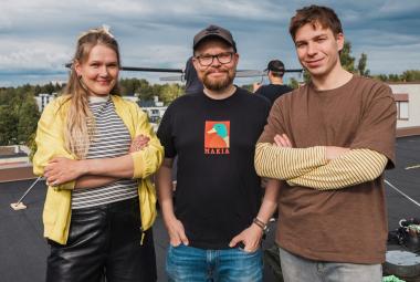 Kuvassa on puolivartalokuvassa ulkona vasemmalla Milla Virtanen keltaisessa villatakissa ja keskellä Antti Heikki Pesonen mustassa t-paidassa. Oikealla on Tom Rejström ruskeassa t-paidassa. 