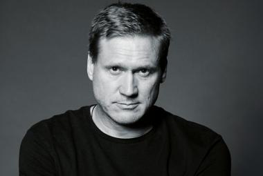 Kuvassa on Samuli Edelmann puolivartalokuvassa. Hänellä on musta paita päällään. Kuva on musta-valkoinen. 